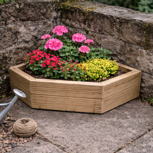Pentagon wooden decking corner planter filled with colourful flowers in garden corner